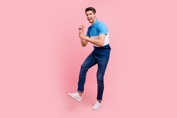 Fototapeta na wymiar Full size photo of funny brunet millennial guy dance wear polo jeans sneakers isolated on pink background