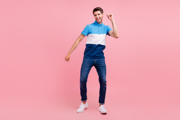 Fototapeta na wymiar Full size photo of cool brunet millennial guy dance wear polo jeans sneakers isolated on pink background