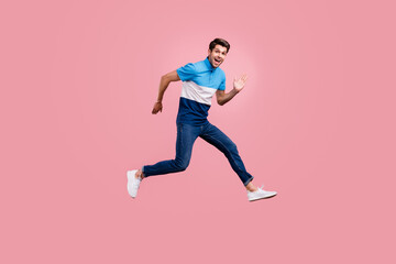 Fototapeta na wymiar Full body photo of funny brunet millennial guy run wear polo jeans sneakers isolated on pink background