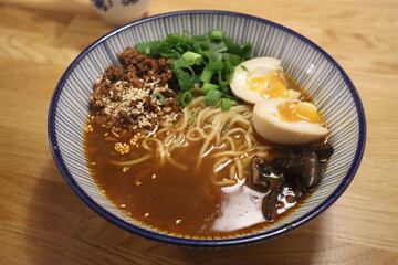 Ramen cooked in pork broth with minced mushrooms, pasta, chopped rings, green onions, corn and boiled egg