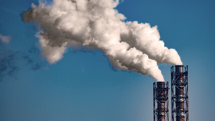Smoke stack of coal power plant on blue sky background. Place for text