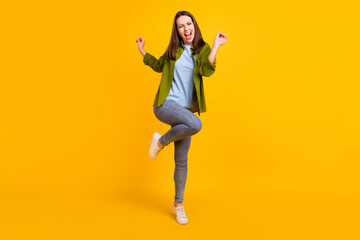 Fototapeta na wymiar Photo of charming funky young lady wear green shirt smiling dancing isolated yellow color background