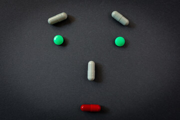 Creative emoticon, surprised face of person realized with different tablets and pills of medicines...