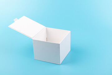 Opened white paper cube box on a blue background.