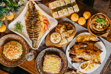 large and generously covered with delicious dishes table on which there are traditional New Year's dishes prepared on the table in the Soviet Union