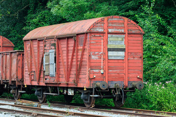 Fototapeta na wymiar old abandoned damaged and weatherd wooden red train cars