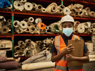 African worker wearing a face mask in a warehouse