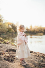 Cute little girl in an autumn forest near lake.