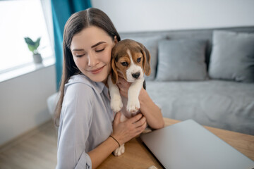 A picture of a young woman with a cute little beagle