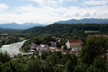 Fototapeta na wymiar View of the western part of the town of Bad Tölz and the Isar river in Upper Bavaria in Germany on a summer day, with the Alps in the distance