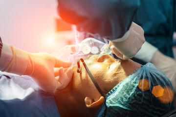 assistant surgeon put the patient on a ventilator-oxygen mask in preparation for surgery.