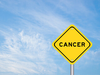 Yellow transportation sign with word cancer on blue sky background