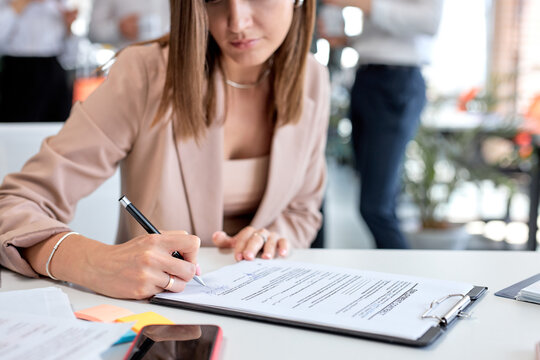 Close-up hand business lady signing financial contract, put write signature on legal corporate paper fill document form buy insurance loan, making business agreement, close up view. business concept