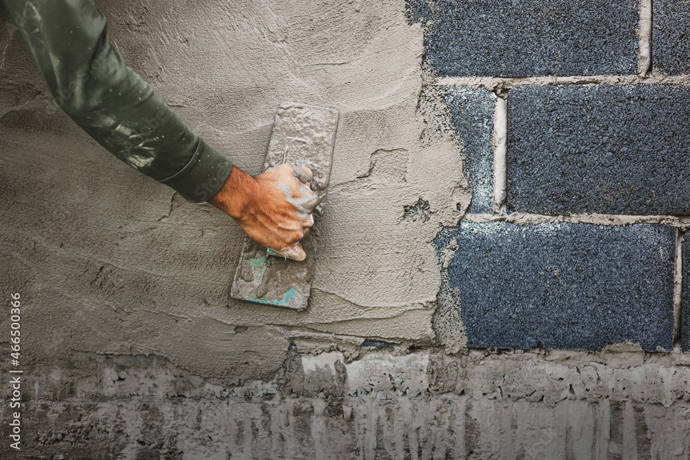 Wall mural closeup hand of worker plastering cement at wall for building house