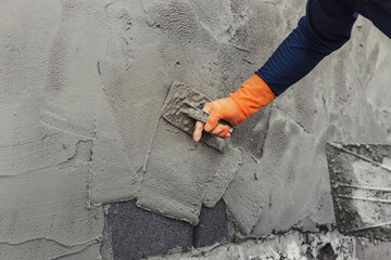 closeup hand of worker plastering cement at wall for building house