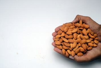 Fresh almonds in the wooden bowl, Organic almonds, almonds border white background, Almond nuts on a dark wooden background. Healthy snacks. Top view. Free space for text.
