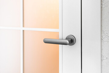 White door with grey door handle and glass