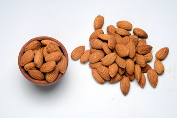 Fresh almonds in the wooden bowl, Organic almonds, almonds border white background, Almond nuts on a dark wooden background. Healthy snacks. Top view. Free space for text.