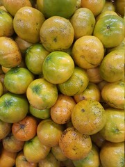 Fresh tangerines with stems and leaves, for sale at market. 
