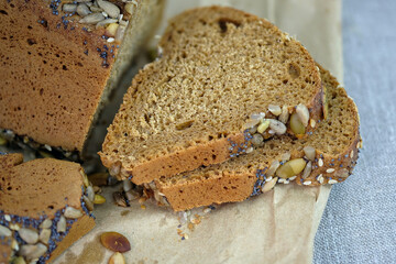 Cereal bread on a tablecloth close-up. Yeast-free bread made with rye flour. Triangular bread with poppy seeds and sunflower seeds.