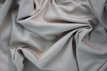 Draped canvas close-up. Abstract polyester fabric background. Top view of fabric with many folds....