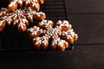 Christmas background with homemade snowflake shape gingerbread cookies on wooden background. New Year celebration traditions concept.