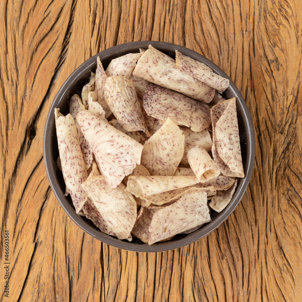 Wall mural Yam or taro chips in a bowl over wooden table