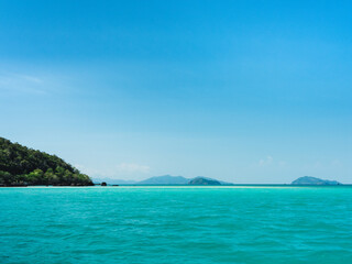 Fototapeta na wymiar Scenic view of peaceful white sand bar and crystal clear turquoise water against clear blue sky. Koh Kham Island, Near Koh Mak Island, Trat, Thailand.