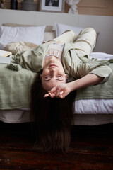 portrait of brunette millennial woman. lying on bed in modern bedroom and dreaming