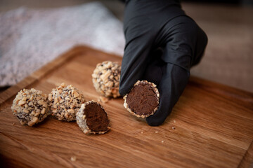 Chocolate with caramel and nuts. Copy space. Close-up. Soft focus background. Hands 