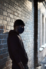 young afro american man in black mask standing at street waiting for victim to commit a crime....