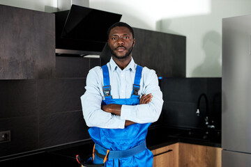 Confident Handsome Young African Handyman Plumber In Blue Uniform. Young Skilled Handyman In...