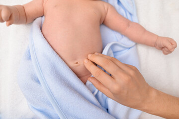 Treatment of newborn baby navel. Mother's hand and newborn's navel. First days after birth. Daily...