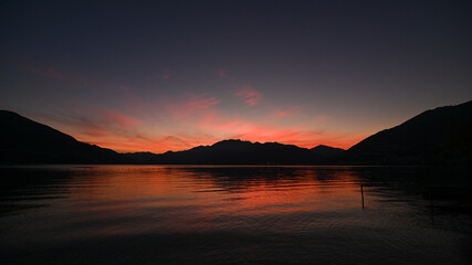 Magnifico tramonto sul lago, con cielo colorato di arancione, rosso, rosa