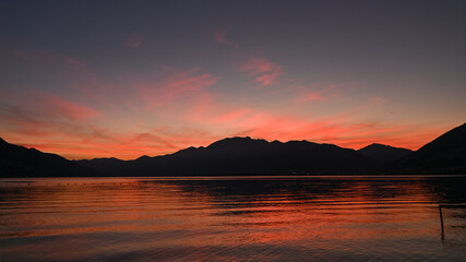 Magnifico tramonto sul lago, con cielo colorato di arancione, rosso, rosa