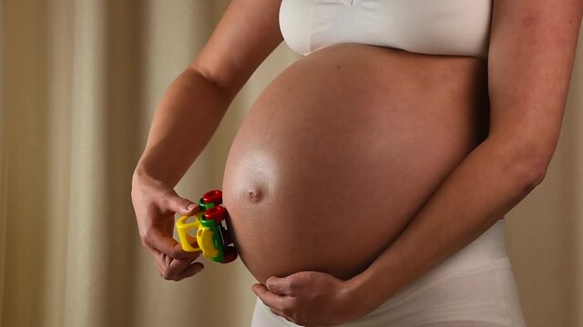 Pregnant woman touching her belly with hands p3