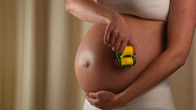 Pregnant woman touching her belly with hands p2