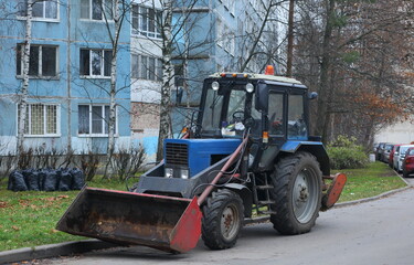 A light tractor is parked in the courtyard of a residential building, Solidarnosti prospekt, St. Petersburg, Russia, November 2021