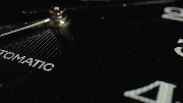 Wall clocks with a logo are made according to an individual project. The black corrugated surface of the dial reflects the falling light. Close-up. High quality. 4k footage.