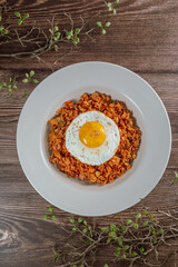 Korean food kimchi fried rice dish with fried egg on white plate