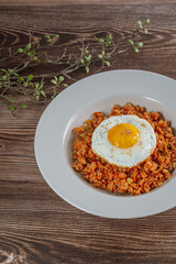 Korean food kimchi fried rice dish with fried egg on white plate