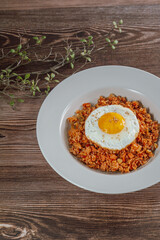 Korean food kimchi fried rice dish with fried egg on white plate