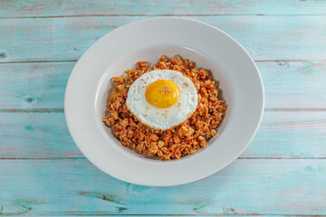 Korean food kimchi fried rice dish with fried egg on white plate
