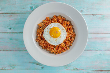 Korean food kimchi fried rice dish with fried egg on white plate