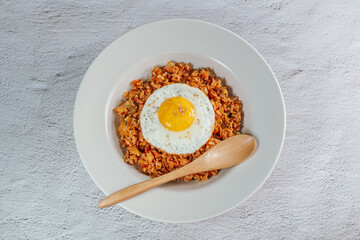 Korean food kimchi fried rice dish with fried egg on white plate