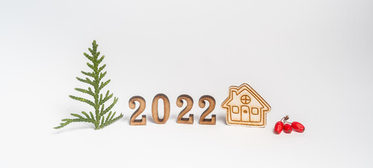 Banner. Wooden numbers 2022. Minimalism and copy space. Small house and Christmas tree on a white background