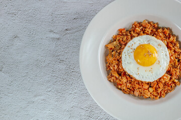 Korean food kimchi fried rice dish with fried egg on white plate