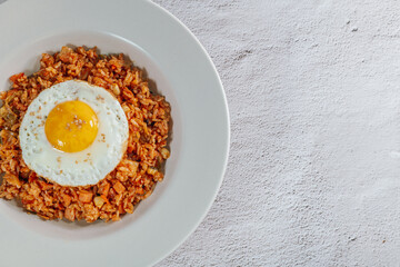 Korean food kimchi fried rice dish with fried egg on white plate