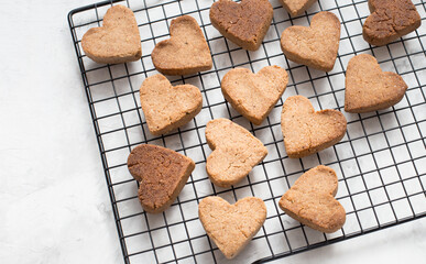 homemade heart-shaped cookies cool on the grill, valentine's day gift with love, gluten-free buckwheat flour pastries.