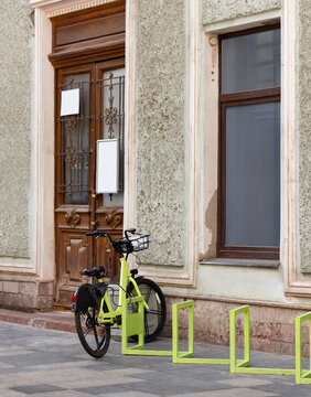 Parking for bicycles and electric scooters in front of an old typical building. The photo.